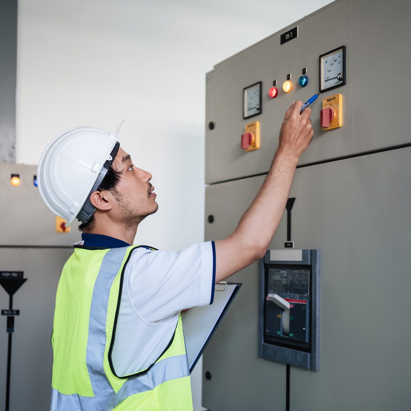 A service engineer checking at the electrical switchboard and check the integrity of the system.