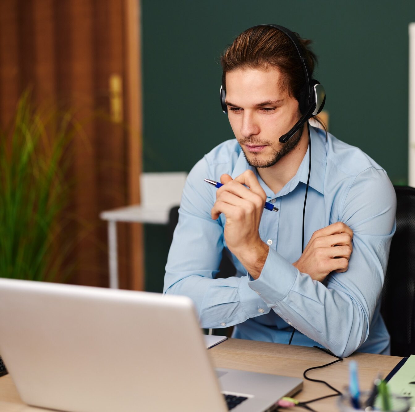 Young man working as customer support in the office